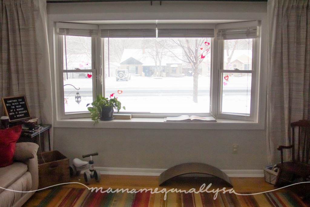 a large bay window with a wobble board and toddler ride on toy on the floor