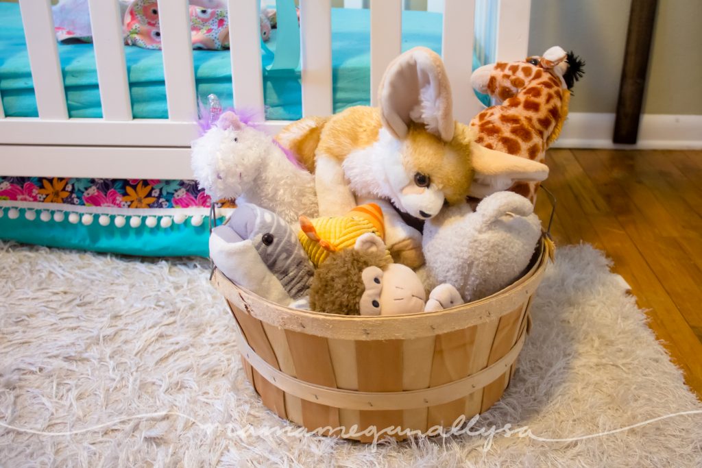 a basket overflowing with stuffed animals in a toddlers room