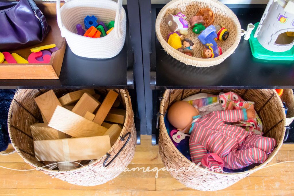 Her big baskets on the bottom of the play shelf, full of wooden blocks and baby dolls