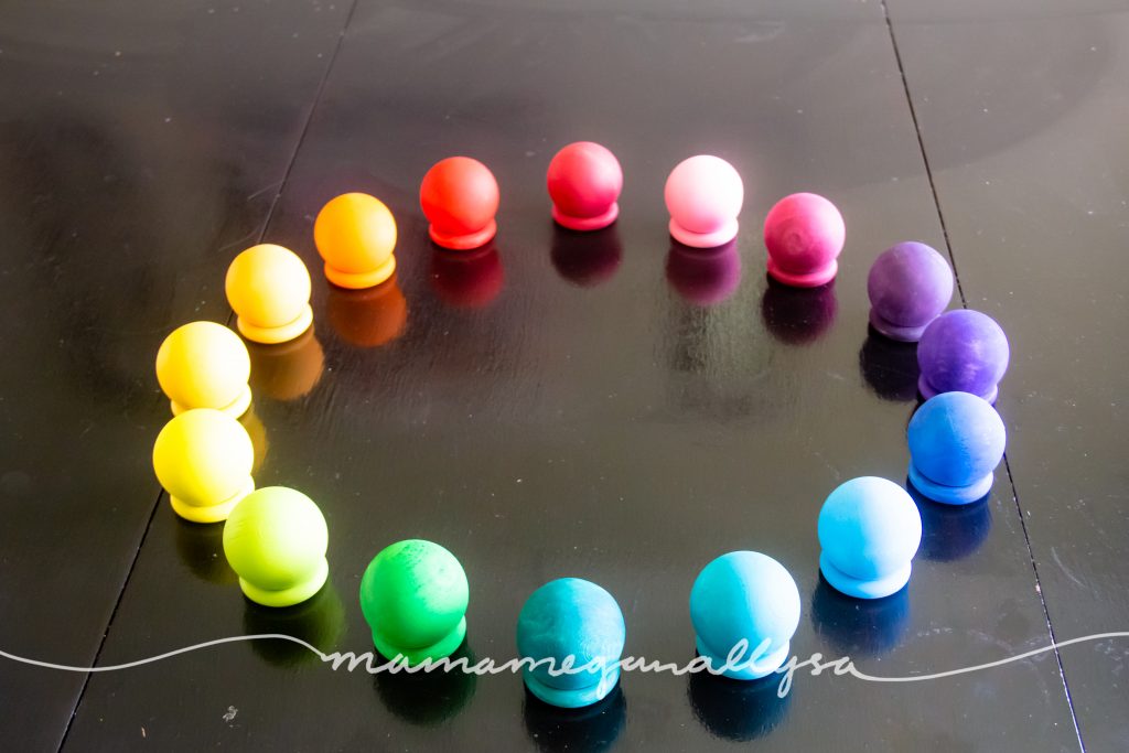 rainbow hand-painted wooden balls stacked on our wooden rings