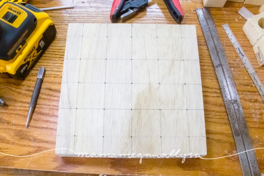 the grid drawn out on the block of wood for the peg people board