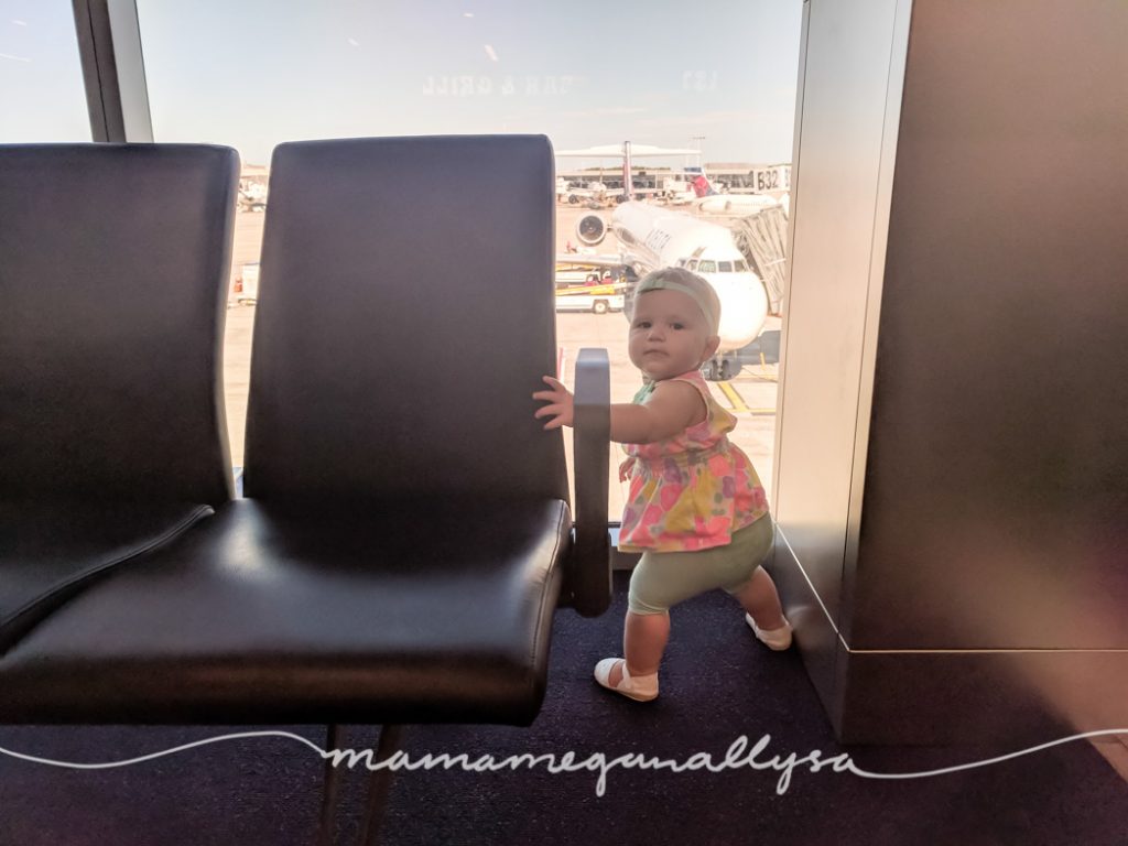 a young toddler watching the airplanes out the window at the airport