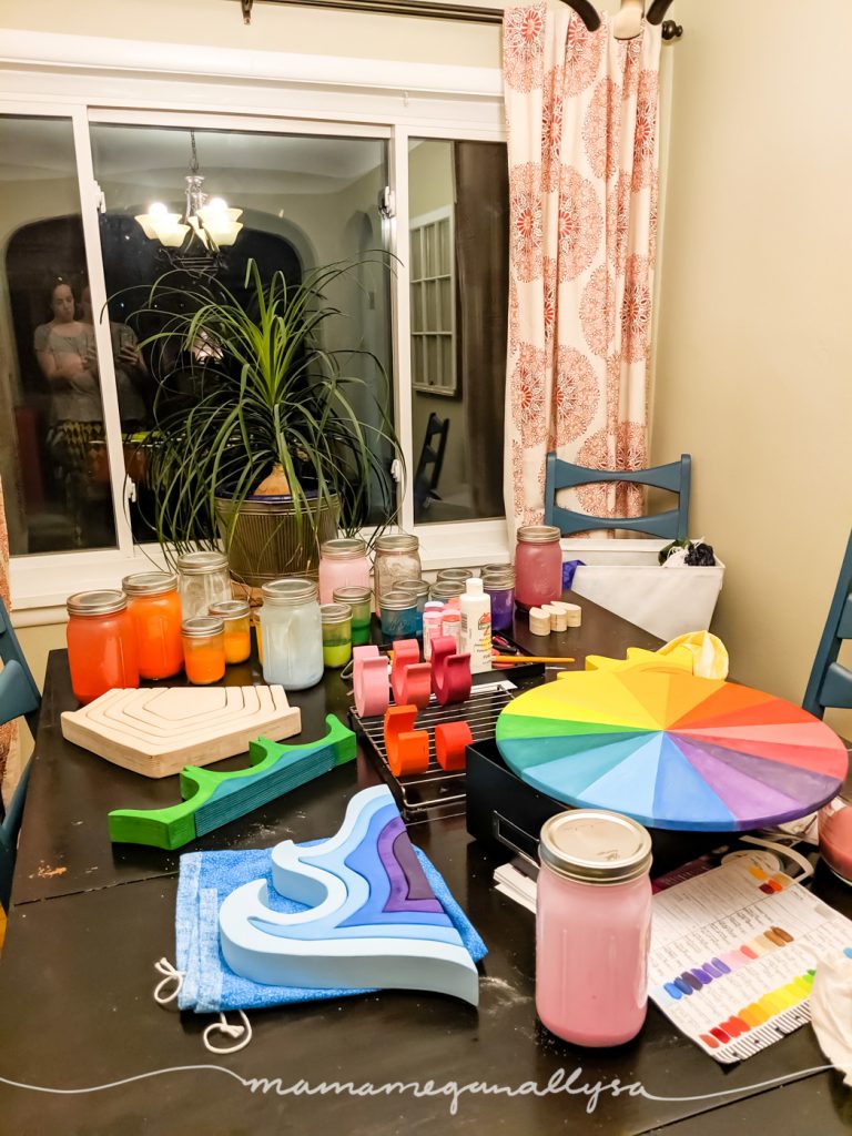 the dining room table covered in projects in the process of being painted