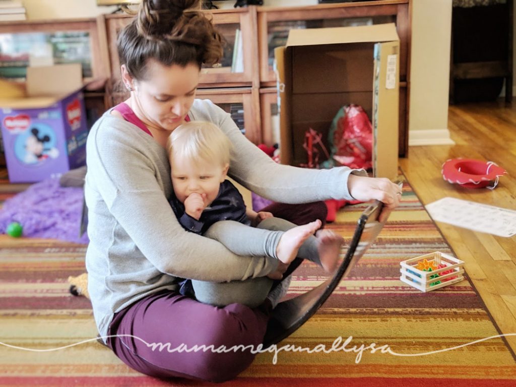 the wobble board or balance board is nothing more than a curve piece of wood. Yet it offers all kind of gross motor challenge in many different ways and its been so fun watching her learn new ways to play with it. 