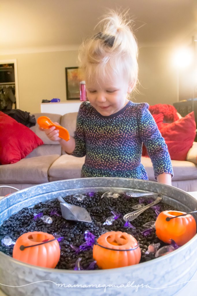 Having a good time exploring the loose parts in our Halloween Sensory bin 