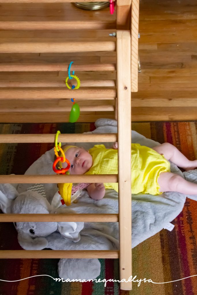 Our baby play space set up at 2 months is some dangle toys and a play mat under the Pikler triangle 