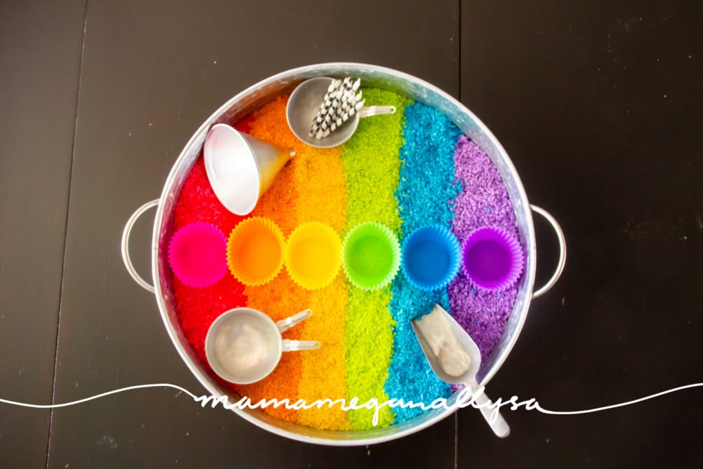 The tools in our rainbow rice sensory bin include a scoop and funnel for filling. Some mini pans and silicone cupcake liners for serving and some candles for posting