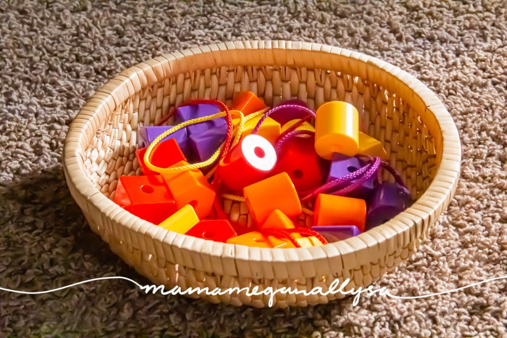 a close up of some plastic lacing beads and strings in a wicker basket