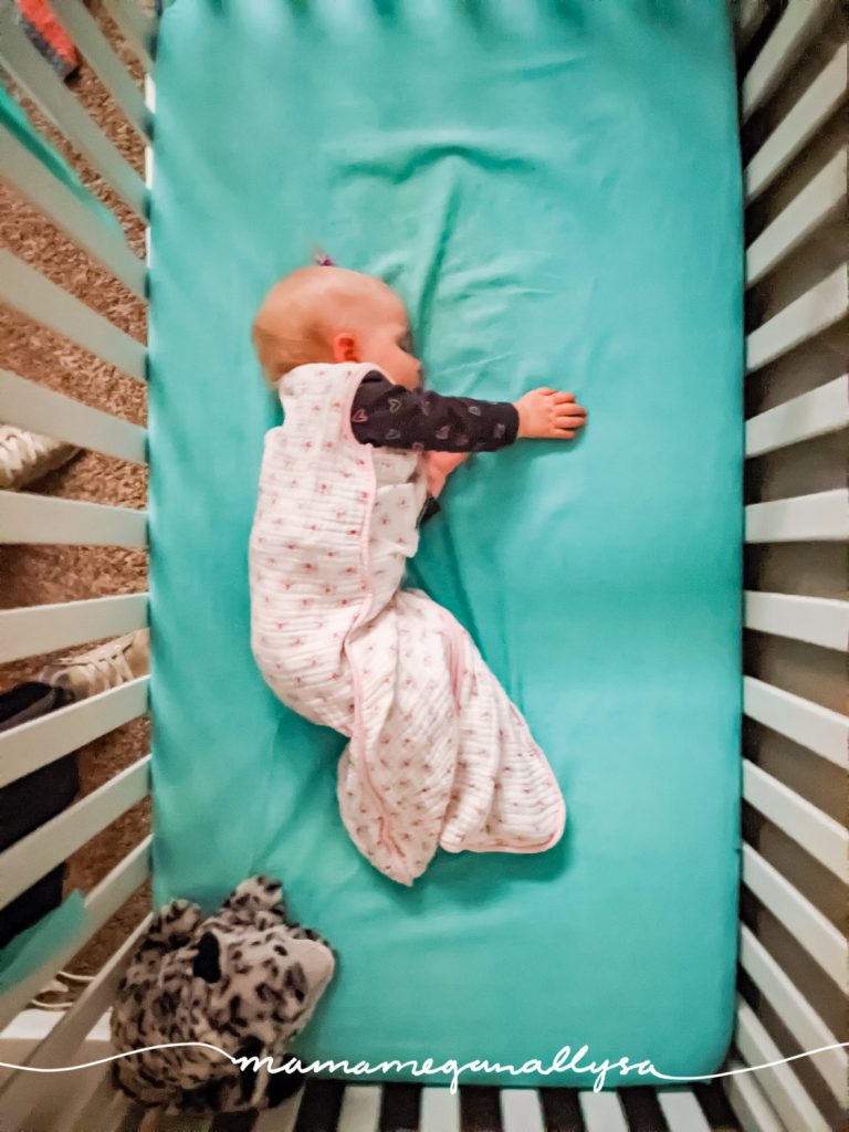 a baby asleep in her crib