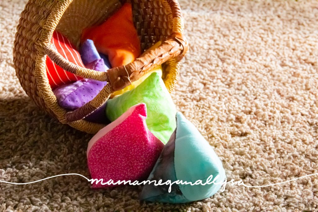 a close up of a basket with a rainbow of homemade bean bags