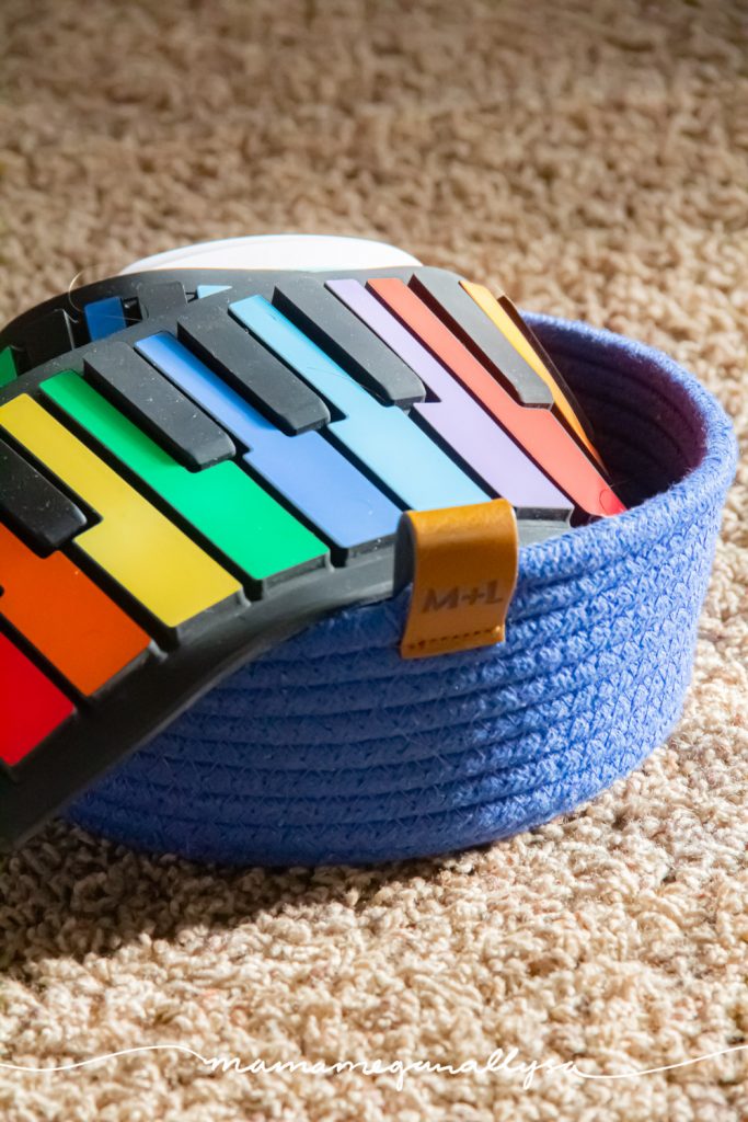 a close up of our rainbow roll up piano in a blue rope basket