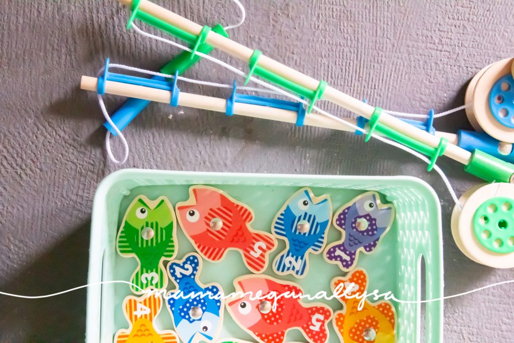 magnetic fishing game and poles in a teal bin on the porch