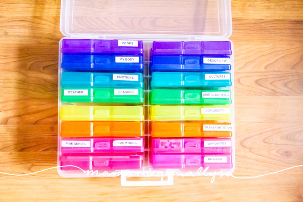 a rainbow flashcard storage box open on the wood floor