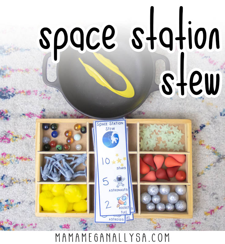 space station stew with a wooden tray with compartments filled with different space themed loose parts like stars, sparkly asteroids, and astronaut toys. A black cast iron pot and yellow tongs sit near by