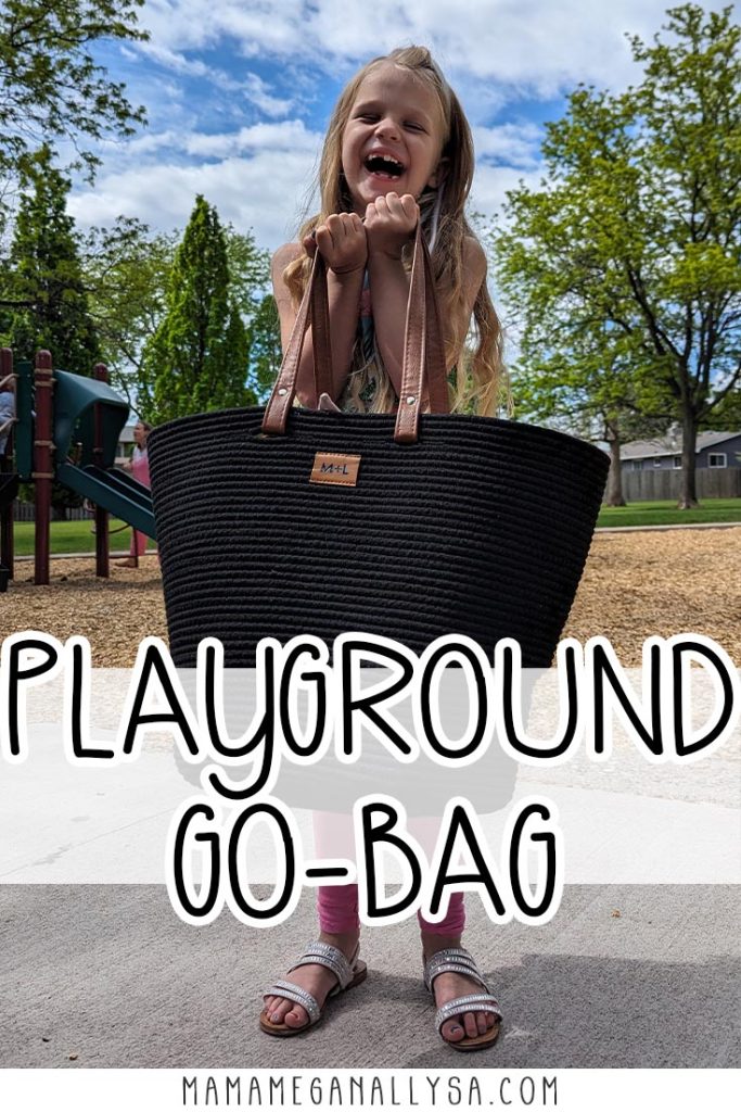 a pin image that reads playground go bag with a image in the background of a 6 year old girl with long blonde hair holding the brown leather straps of a black rope tote bag. She is laughing while she attemps to hold the bag that is nearly as bag as she is